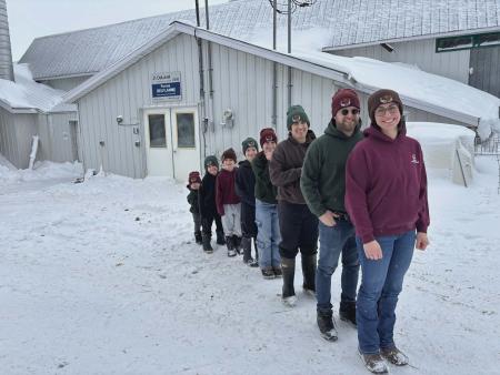 Emmanuelle et Simon, accompagnés d’un employé de la ferme, Orvil, et de leurs cinq enfants. 