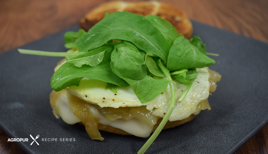 Mozzarella and egg bagel with caramelized onions and arugula