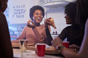 Getty 1093189220 - Young women having party in the kitchen and eating pizza