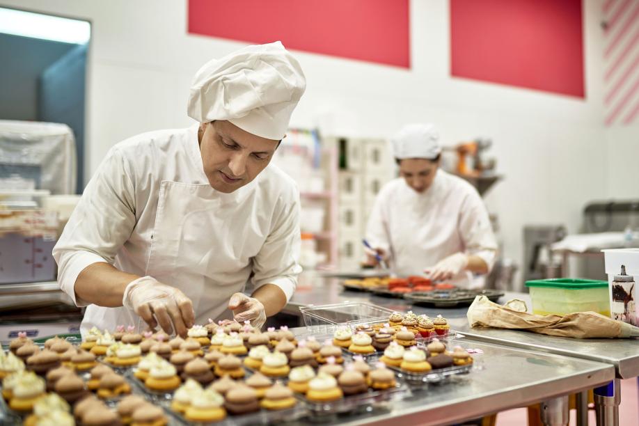 Hispanic American Chef Decorating Vegan Cupcakes in Kitchen