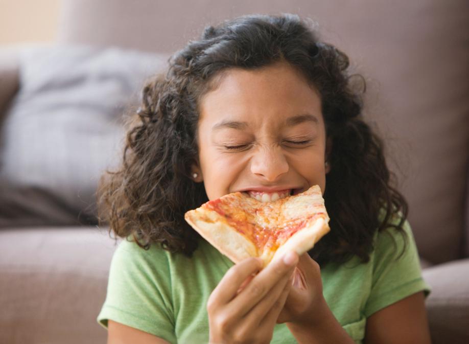Getty 149616534 - Hispanic girl eating pizza